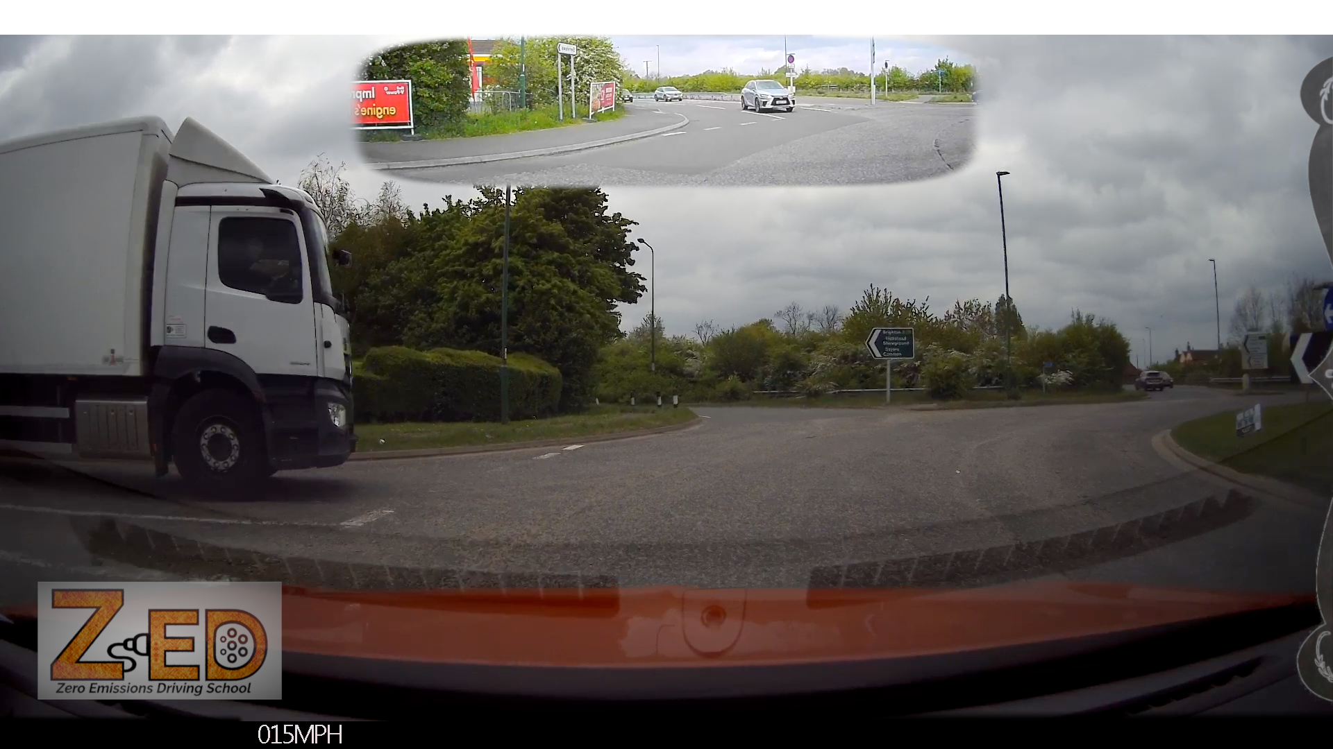 View of a truck joining a roundabout, shown from a 360-degree in car camera system on a cloudy day.