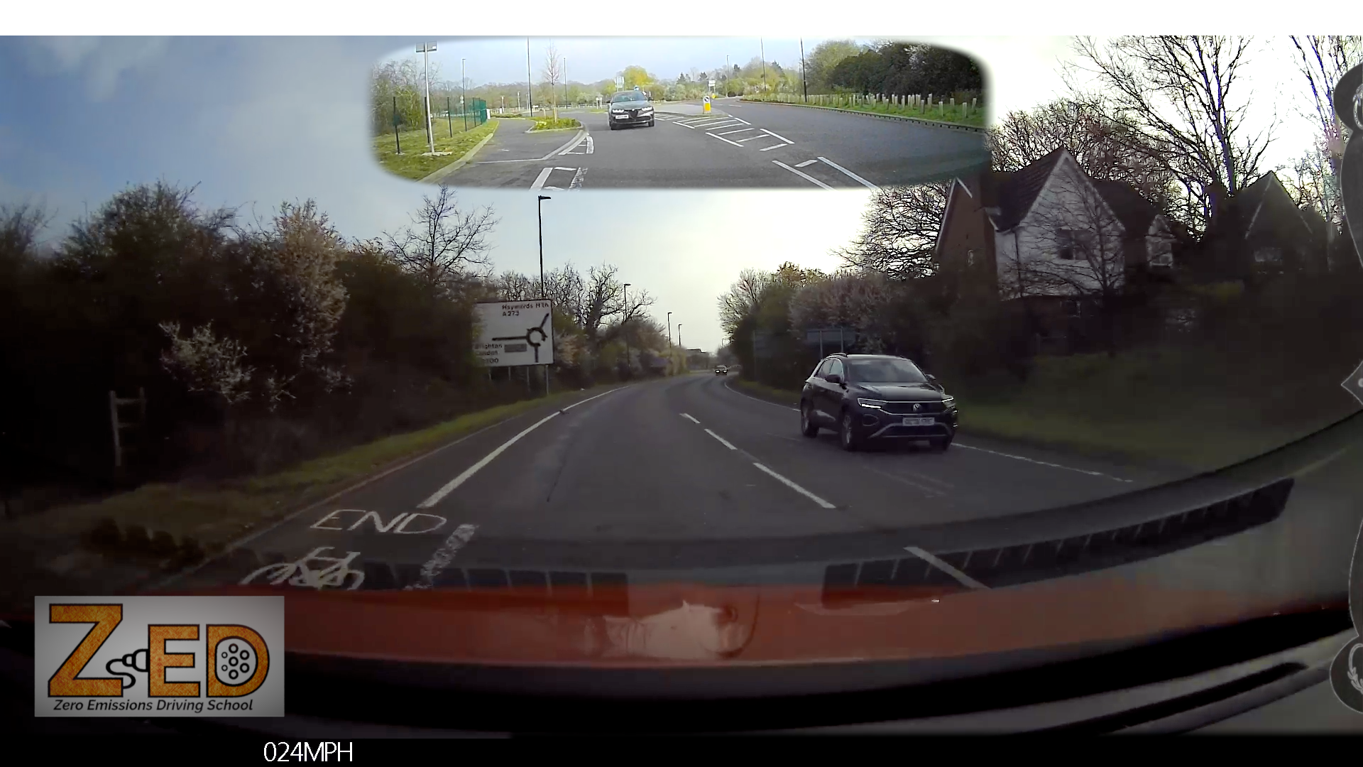 Car driving on a road with a split-screen showing a top-down view of the intersection.