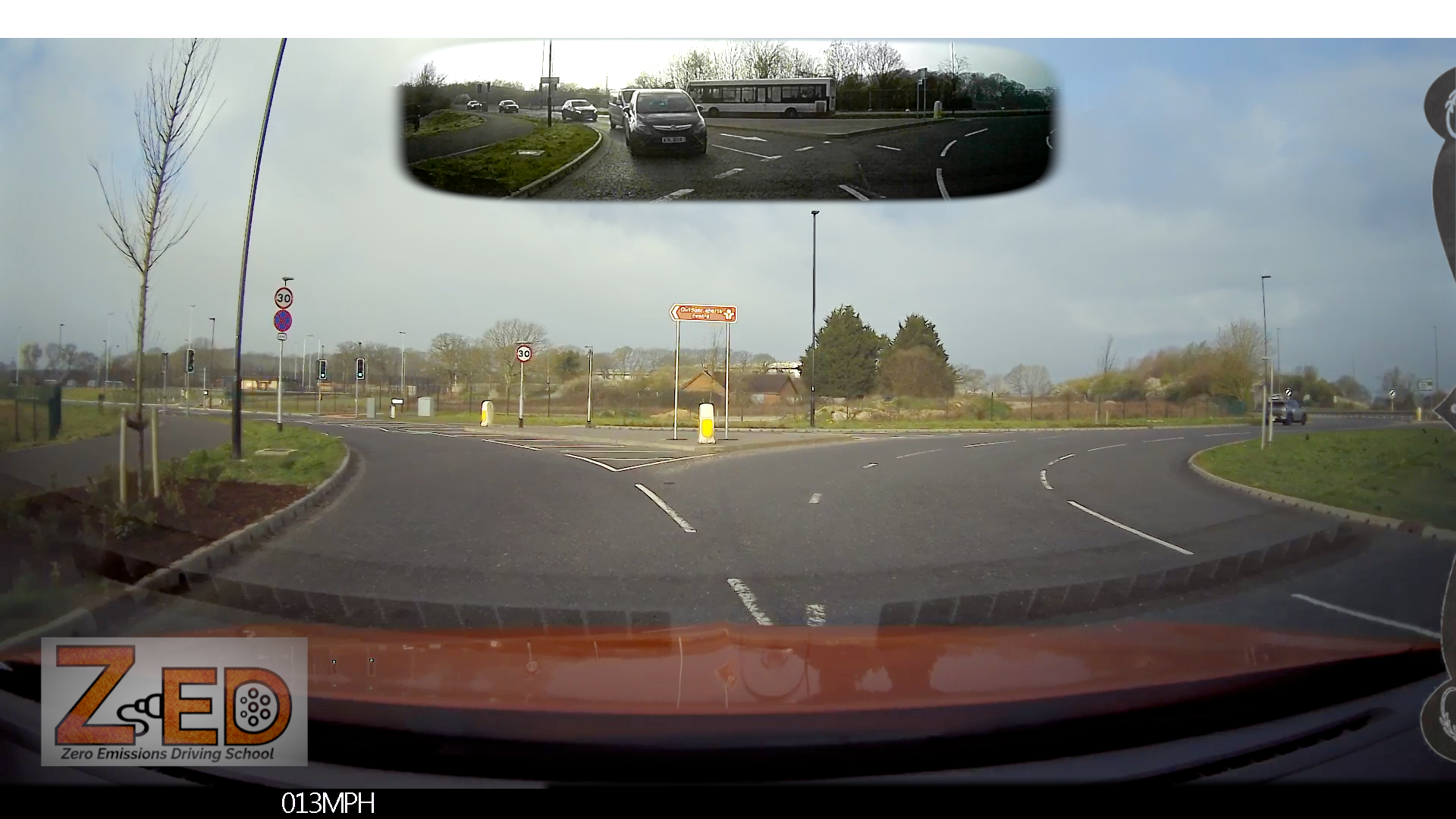 Car's rear view mirror showing a split-screen view of the road and a speedometer, with 'ZED' branding.