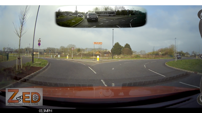 Car's rear view mirror showing a split-screen view of the road and a speedometer, with 'ZED' branding.