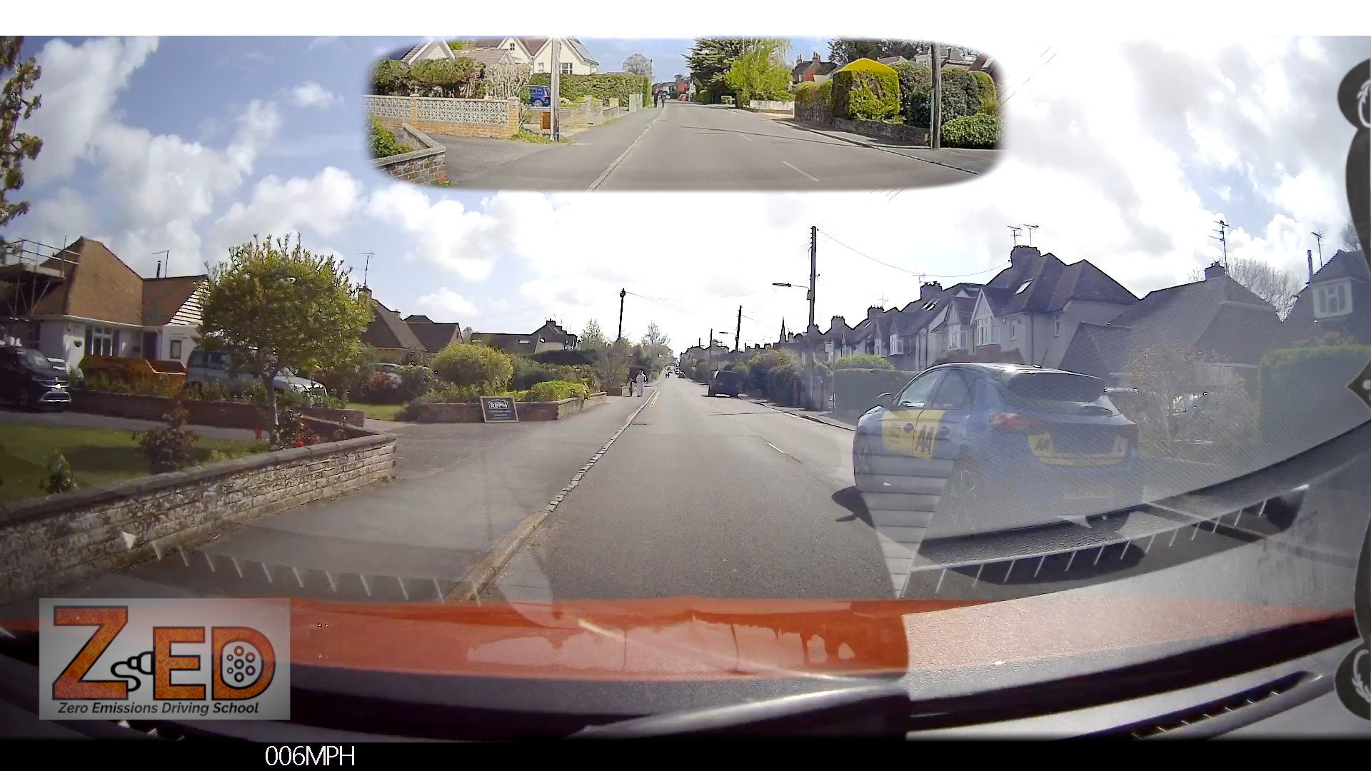 Car dashboard view with a ZED device displaying speed, showing a residential street.