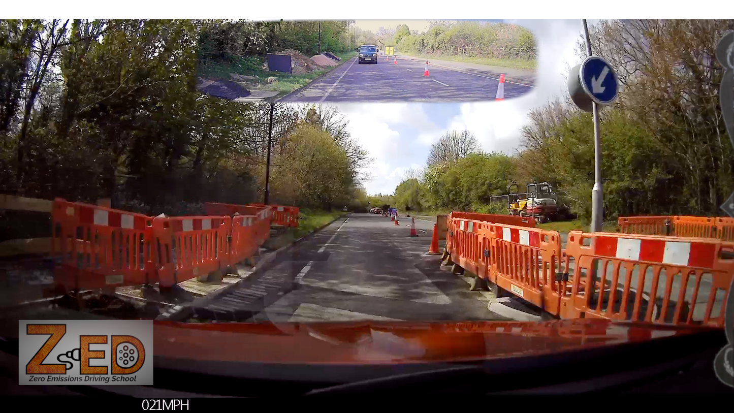 360-degree view of a road with barriers and a driving instructor's perspective overlay.