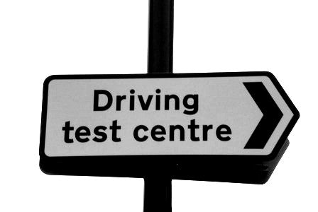 A road sign showing the direction to the driving test centre